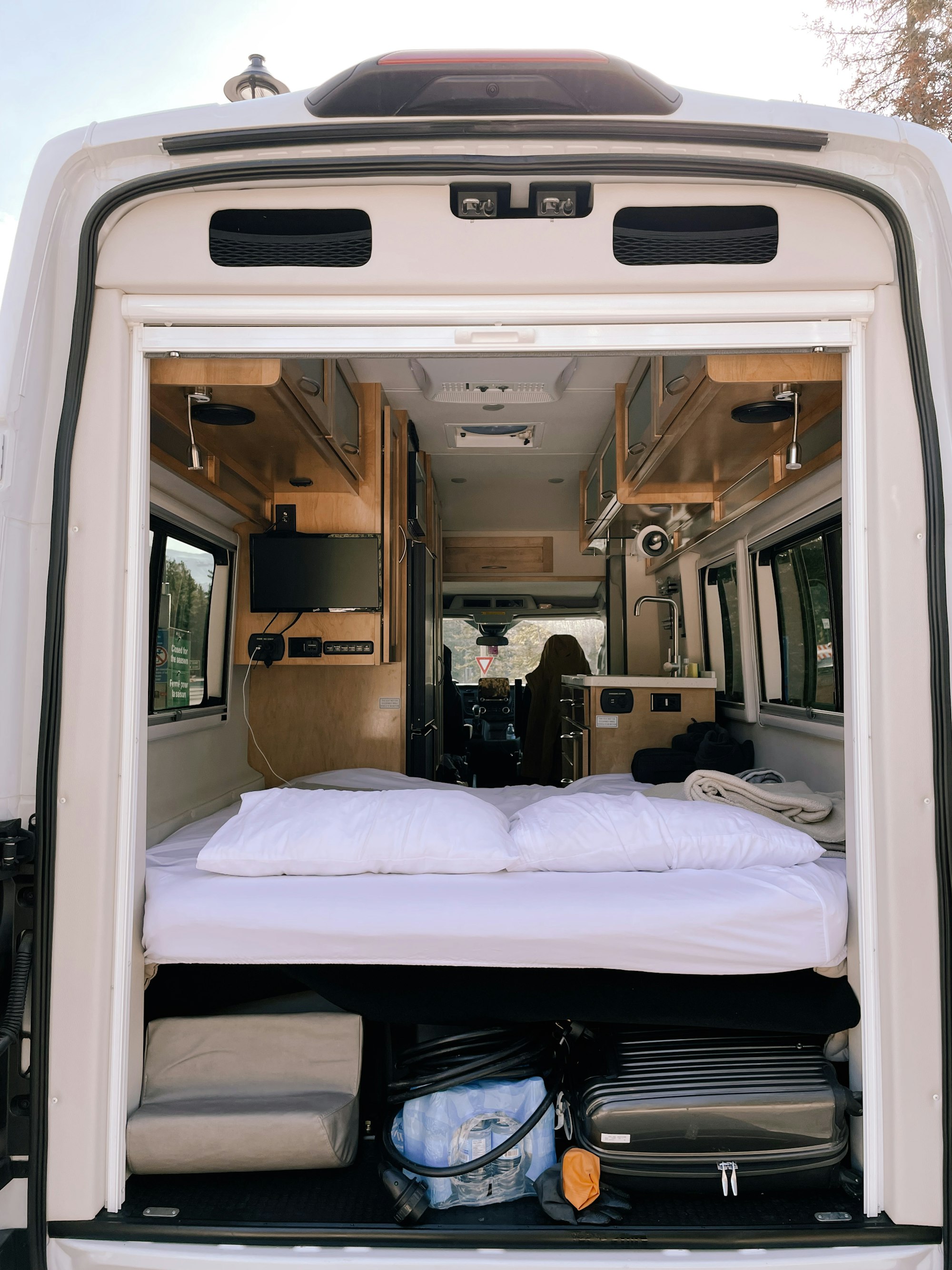 Innenraum eines ausgebauten Kastenwagens mit Bett und Sitzbank