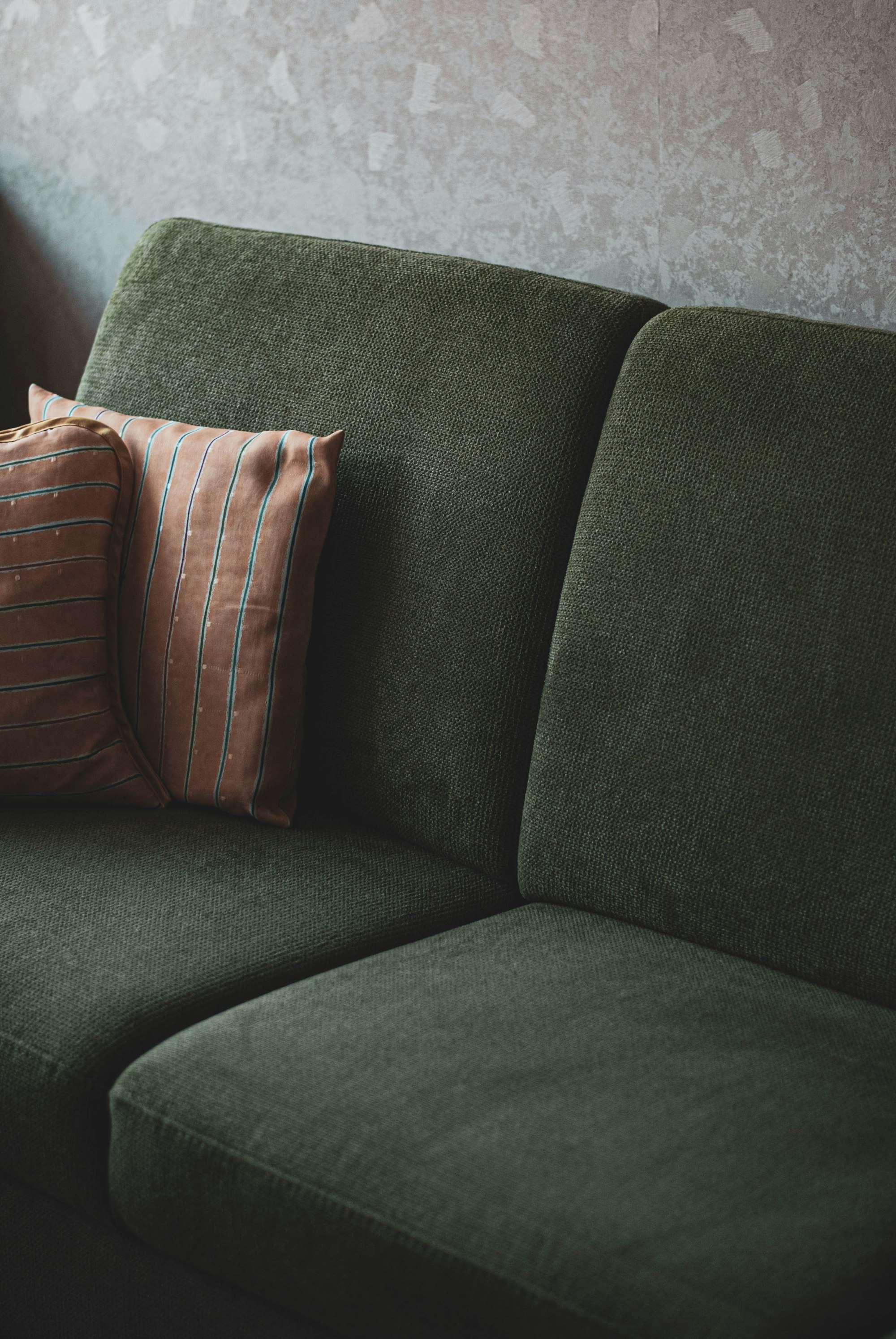 Grünes Sofa mit losen Sitz- und Rückenkissen